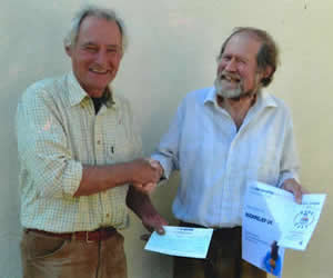 Barry Evetts receiving a cheque from Jeremy Bell